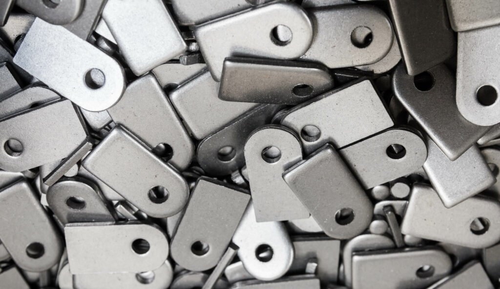 Steel plate cut out according to pattern, background image. Manufacturing process - steel cutting in factory. Stamping plates of complex shape ready for the next step.